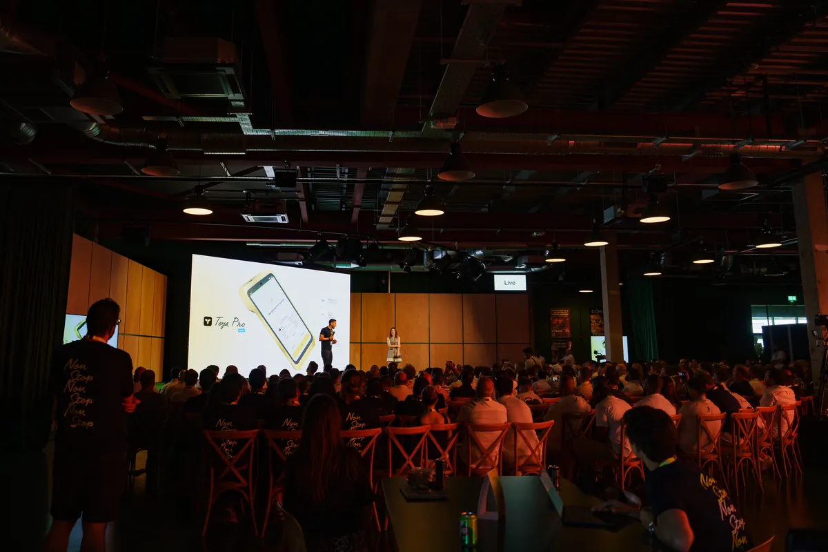 A "Business. Non-stop." keynote stage with an audience watching.