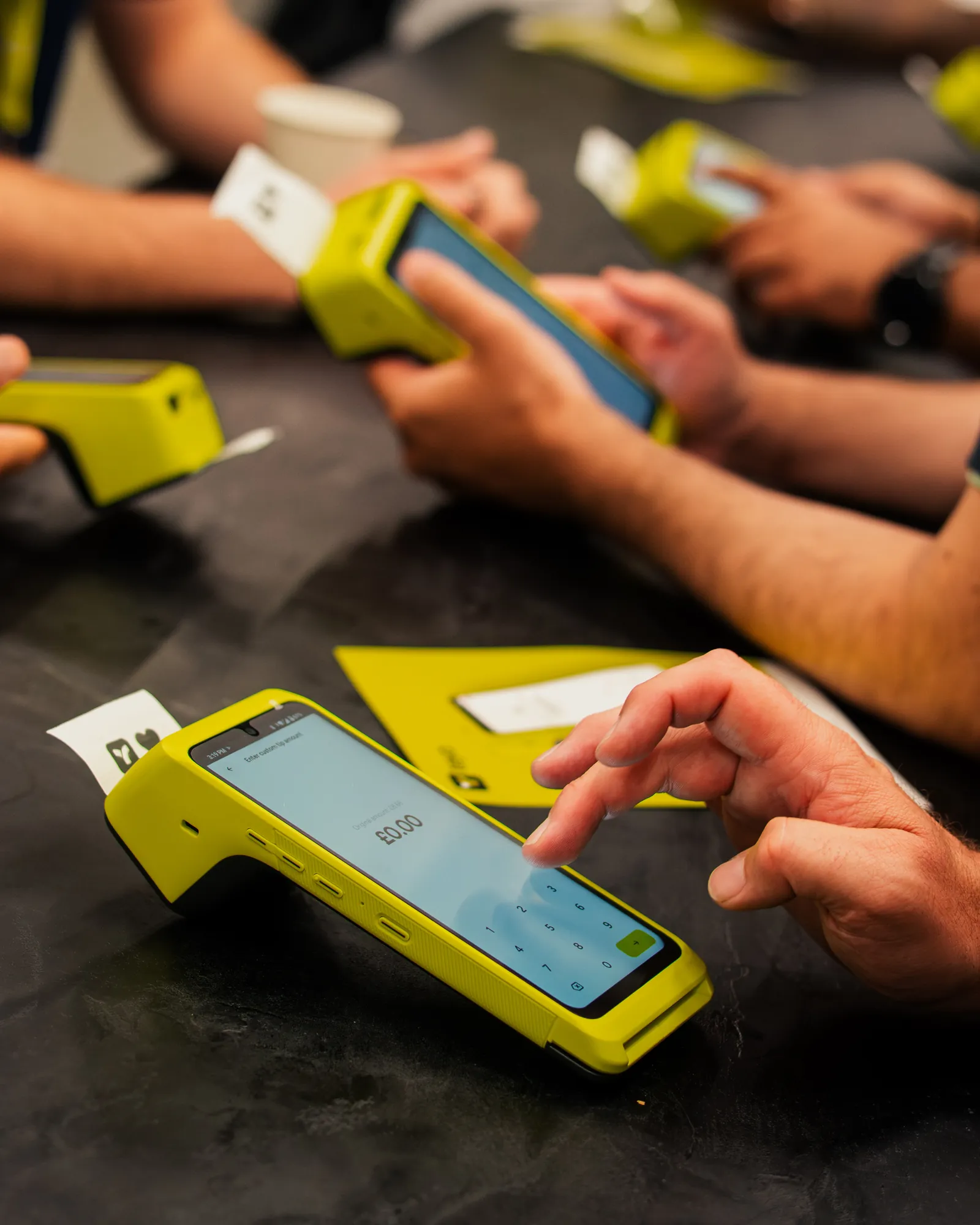 A customer tapping a card on Teya Pro at a table, a receipt printing